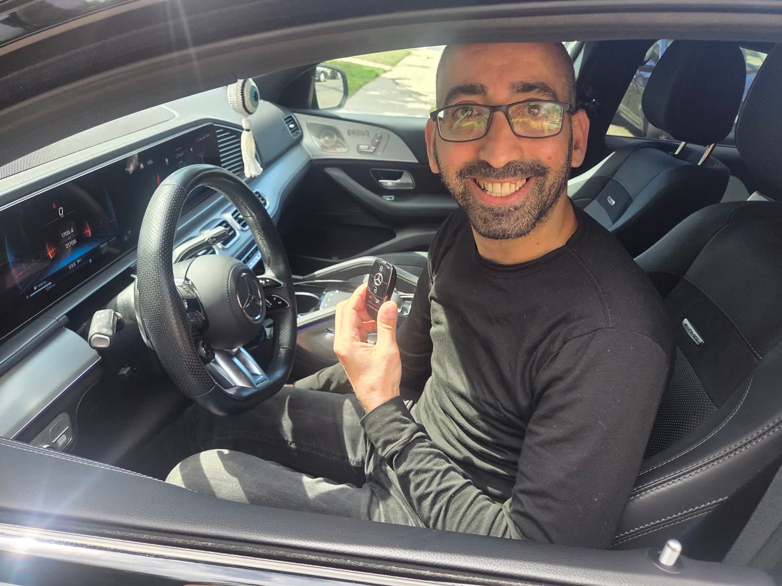 A happy LockAngeles customer holding a newly cut key inside their Mercedes in Los Angeles